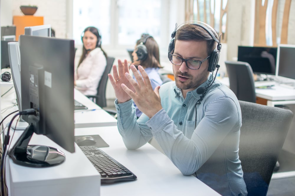 A young man answers the phone at a call center