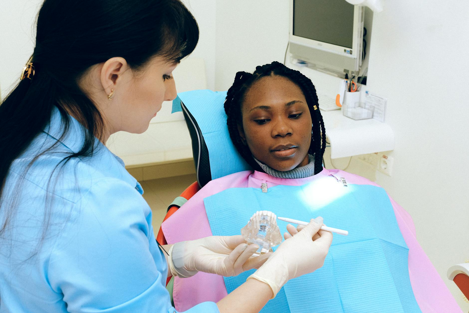 Close-up of a dentist examining a patient's chipped tooth.