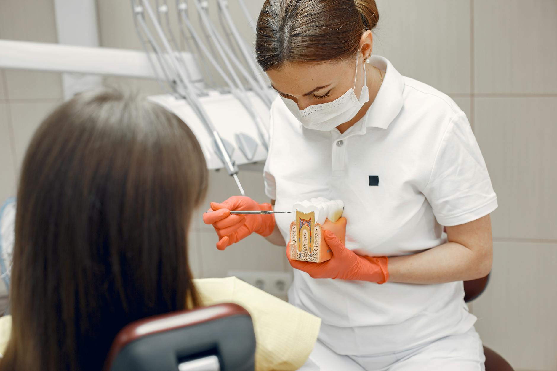 Dentist examining a patient's teeth during an emergency visit.