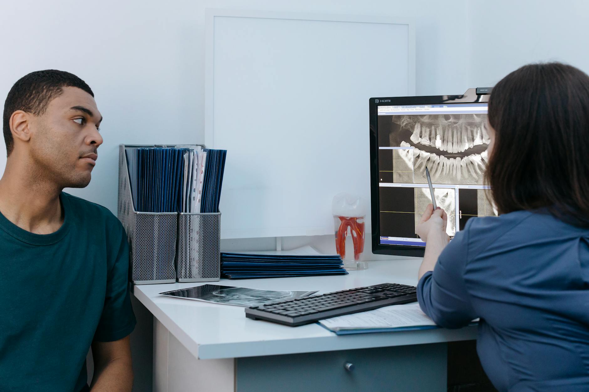 Dentist examining a patient's teeth during an emergency visit.