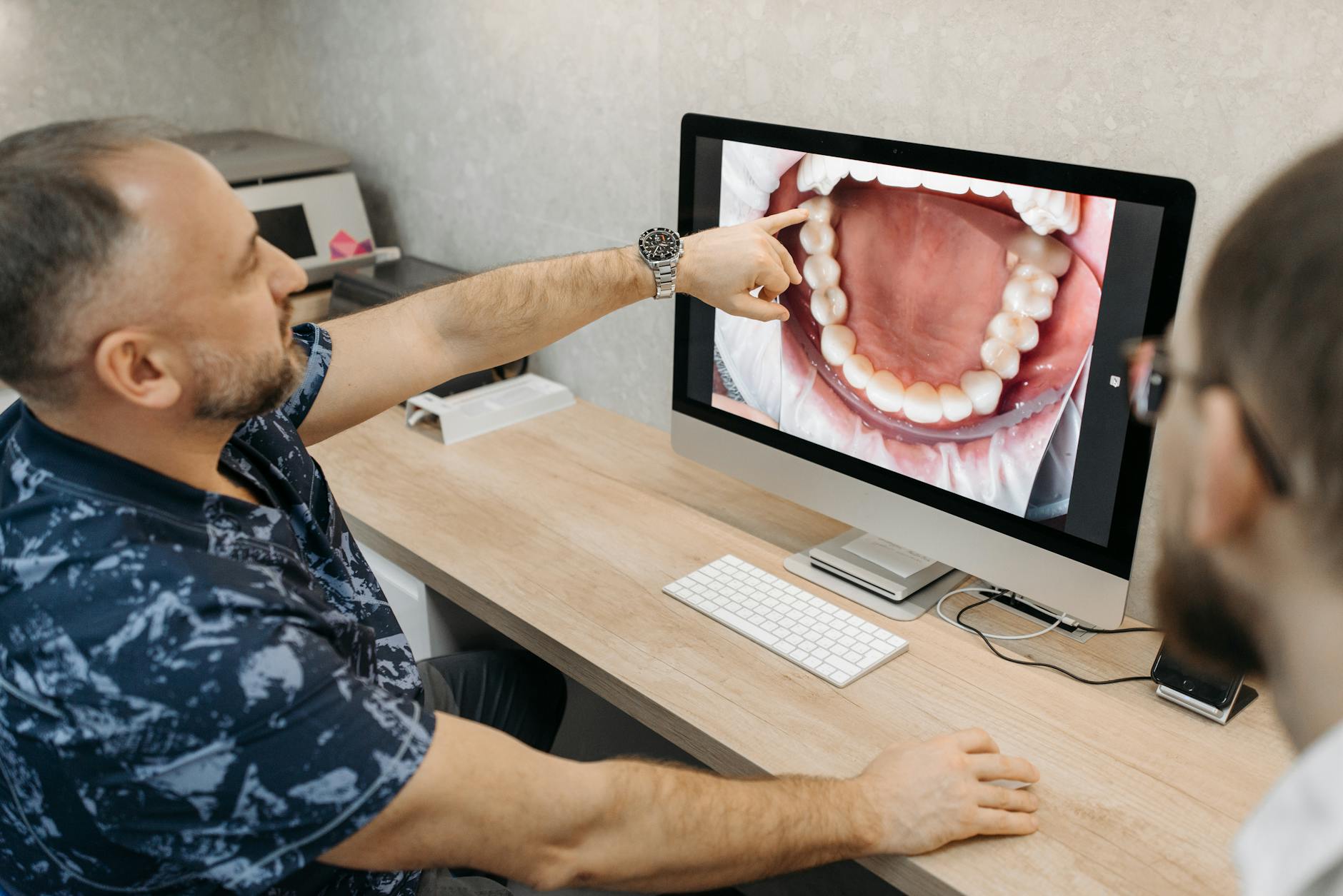 Dentist examining a patient's teeth, likely related to wisdom tooth removal.