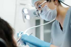 Close-up of a dentist examining a patient's teeth, indicating dental pain.