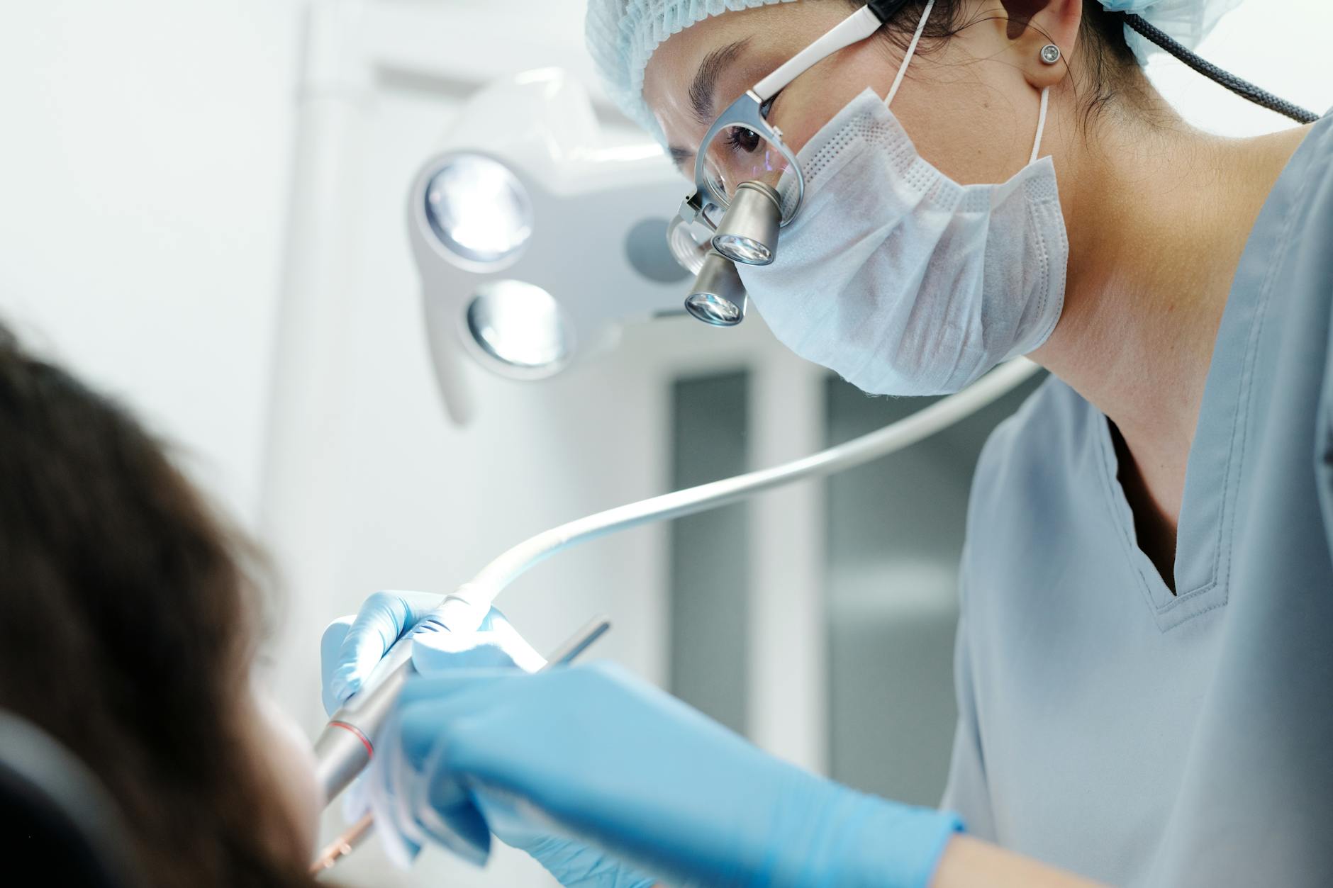 Close-up of a dentist examining a patient's teeth, indicating dental pain.