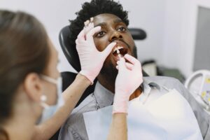 Dentist examining patient's mouth for broken filling repair