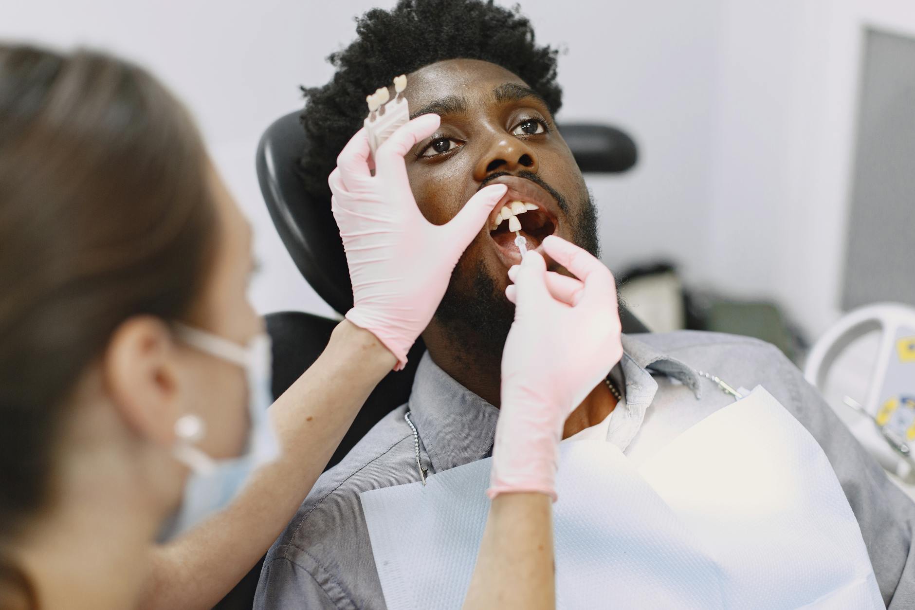 Dentist examining patient's mouth for broken filling repair