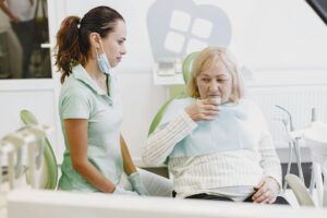 Dentist examining a patient's broken tooth for a temporary fix.