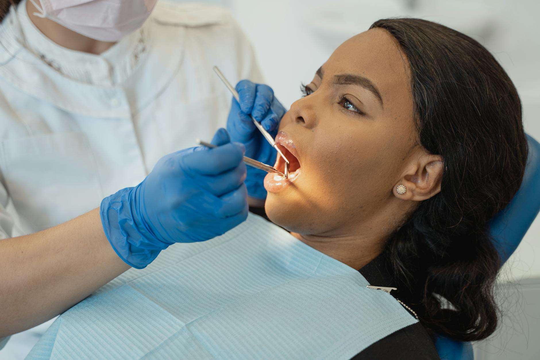 A dentist examines a patient's mouth, discussing root canal procedures.