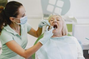 Dentist examining a patient's teeth for cavity tooth pain.